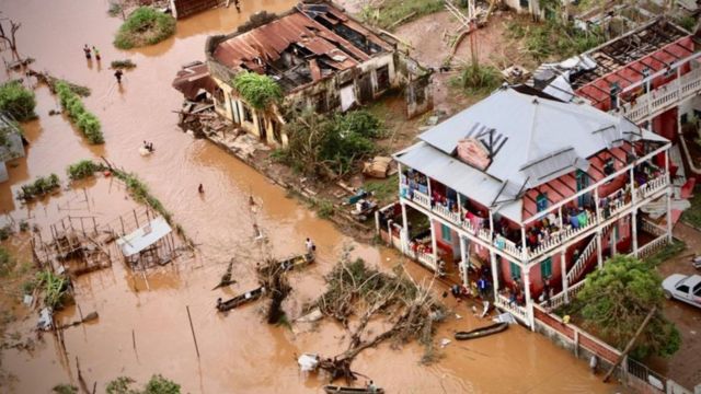 People walk on the flooded street of Buzi, central Mozambique, on March 20, 2019 after the passage of the cyclone Idai