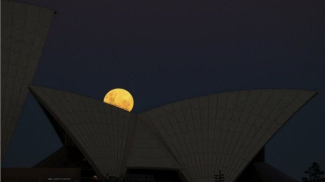 A superlua surge atrás da Sydney Opera House em noite de eclipse lunar, em Sydney, na Austrália