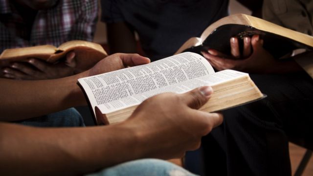 Close-up of people's hands with bibles in a conversation wheel