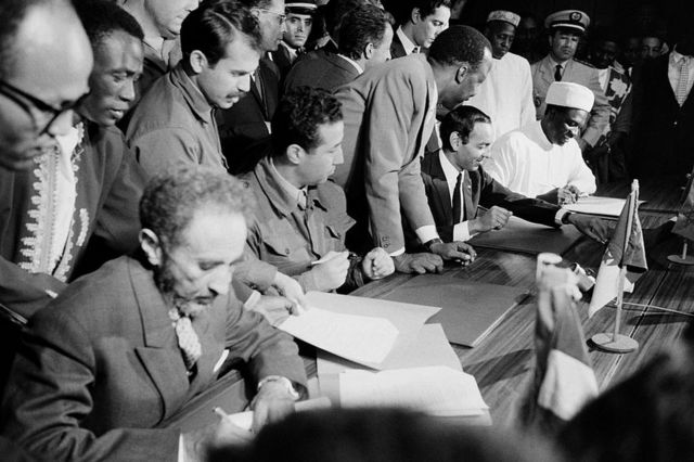 Hyla Selassie signs a document