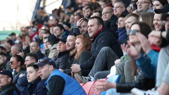 Fans cheer, as they are watching the Belarusian Premier League soccer match between FC Minsk and FC Dinamo-Minsk in Minsk o­n 28 March