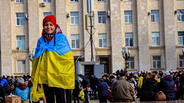 Niño con la bandera de Ucrania celebra la liberación de Jersón por parte de las fuerzas ucranianas el 19 de noviembre de 2022.
