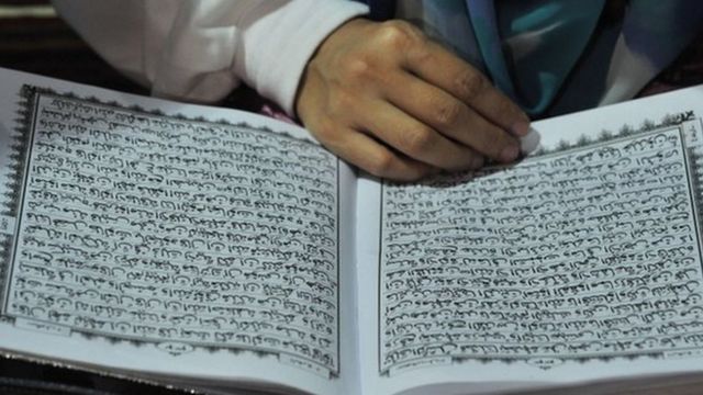 Quran kitabını oxuyan qadın