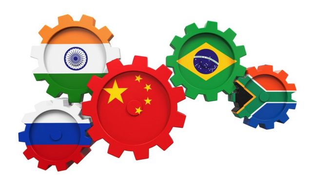 Engrenagens com ilustrações de bandeiras sobrepostas representam países pertencentes ao bloco dos BRICS: Brasil, Índia, China, África do Sul e Rússia