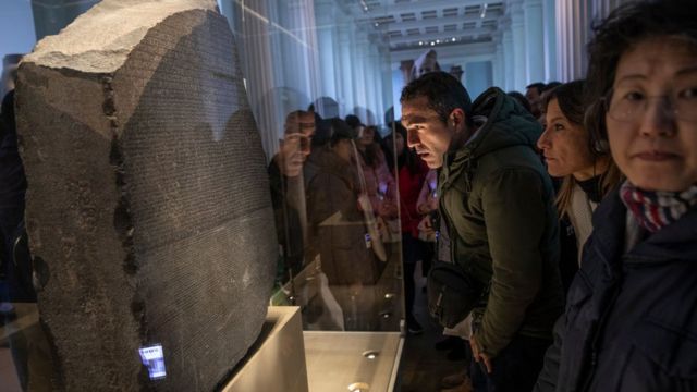 El público observa la piedra de Rosetta.