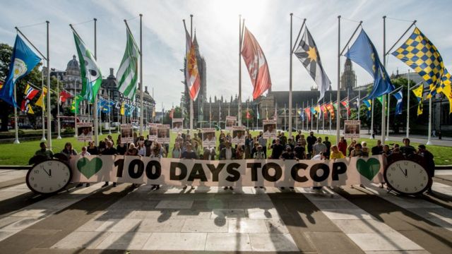 ناشطون يحملون لافتات في ساحة البرلمان البريطاني في لندن قبل 100 يوم من انعقاد قمة المناخ في غلاسكو ويطالبون بمعرفة الإجراء الذي سيتولاه رئيس الوزراء بشأن تغير المناخ.