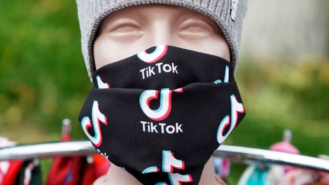 Maniquí con la boca tapada con pañuelos con el logo de TikTok.