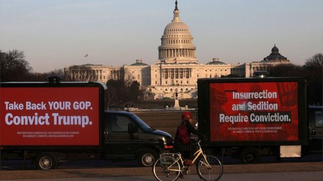 На Национальной аллее, за которой видно здание Капитолия, припаркованы грузовики с надписями в поддержку осуждения бывшего президента США