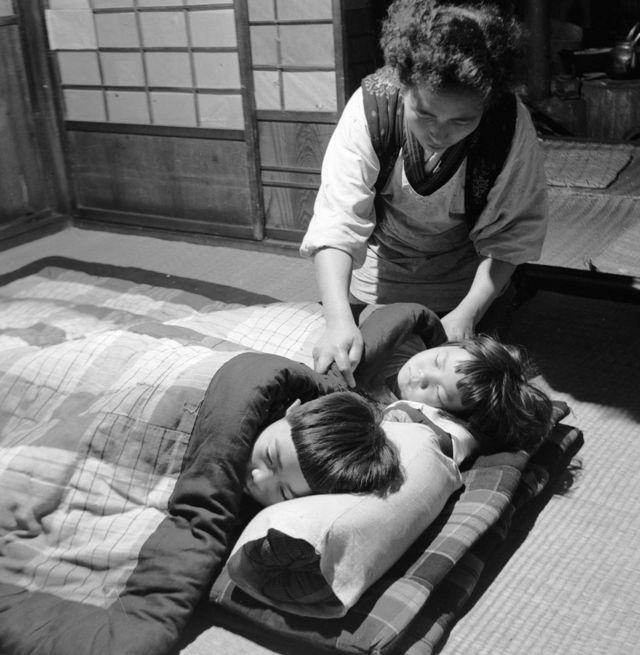 Niños japoneses en la cama y una mujer