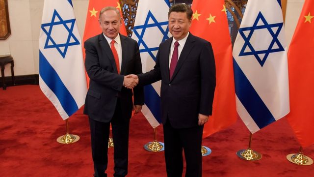 El primer ministro israelí, Benjamin Netanyahu; y el presidente de China, Xi Jinping, se dan la mano.