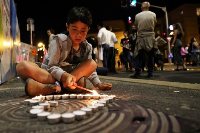 صبي في القدس يوقد شمعة على أرواح الضحايا