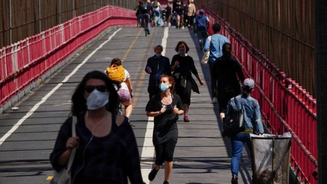 People crossing the Williamsburg bridge in New York wearing face masks