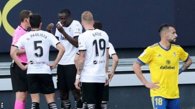 Valencia defender Mouctar Diakhaby talks with referee David Medie Jimenez after an alleged racist comment by a Cadiz player