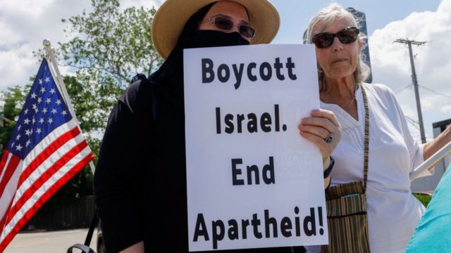 امرأة تحمل لافتة تدعو إلى مقاطعة اسرائيل وإنهاء الفصل العنصري، في ولاية أوهايو الأمريكية