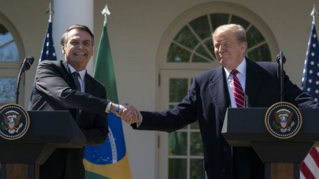 Bolsonaro e Trump apertam as mãos e sorriem em encontro nos EUA