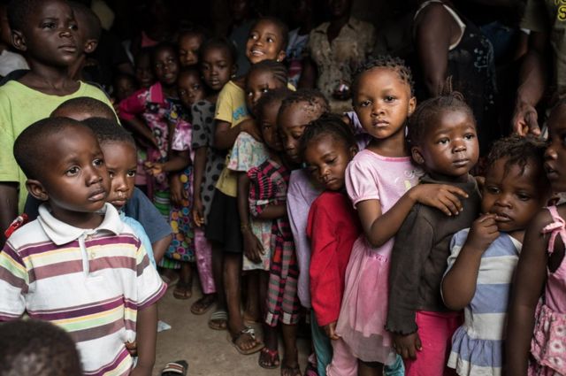 Children staying in the half built house queue up to receive clothes donated by some Lebanese women who live in Freetown