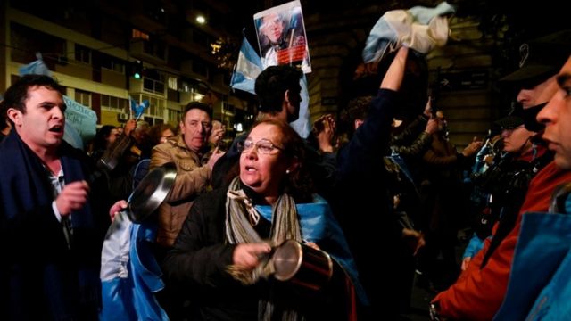 Varios manifestantes en la calle por la noche