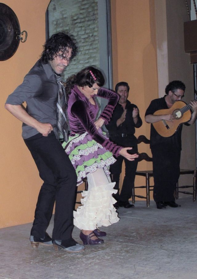 Dos bailarines de flamenco acompañados por una guitarra y un cantante