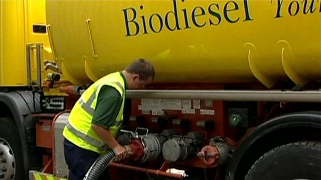 An employee fills a tank of a truck with diesel fuel