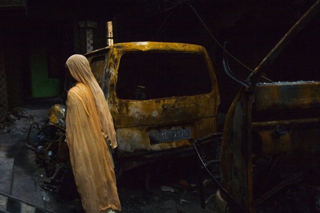 Kendaraan terbakar di Khajuri Khas yang dilanda kerusuhan.
