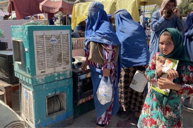 فتاة في سوق للأغراض المستعملة في مزار الشريف في أفغانستان حيث اضطر بعض الأفغان لبيع ممتلكاتهم لتغطية نفقاتهم