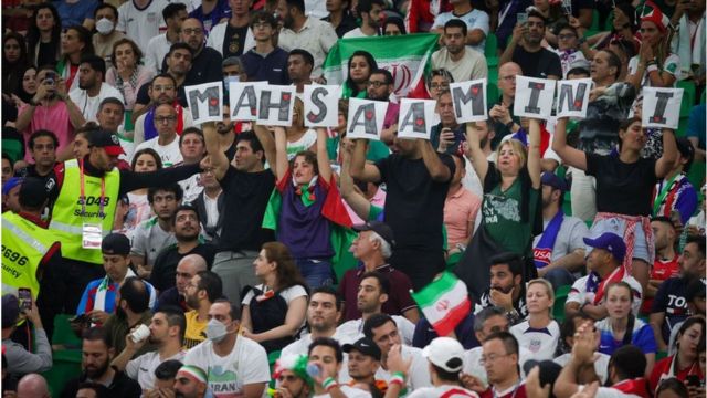 Aficionados iraníes con pancartas con el nombre de la asesinada Mahsa Amini.