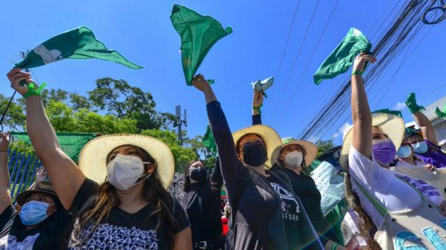 Mulheres abanam bandanas verdes em protesto a favor da descriminalização do aborto em San Salvador