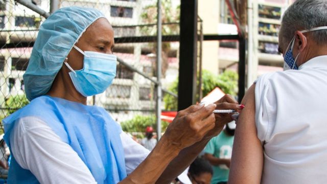 Enfermeira aplicando vacina em paciente na Venezuela