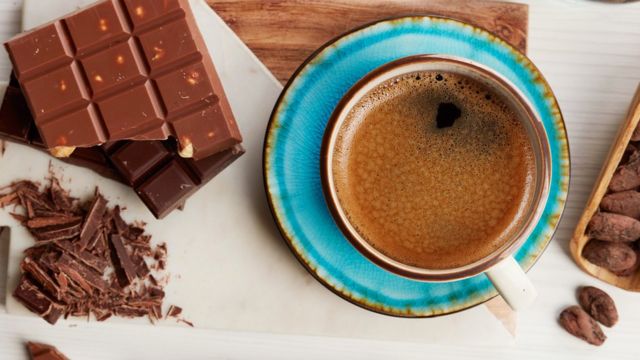 Barra de chocolate ao lado de uma xícara de café