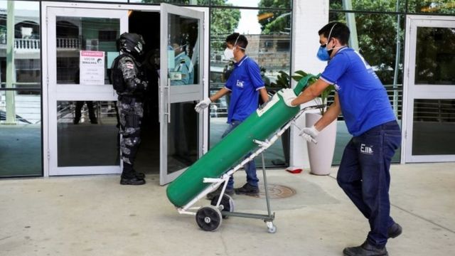 A worker arrives with an oxygen cylinder at Getulio Vargas hospital, amid the coronavirus disease