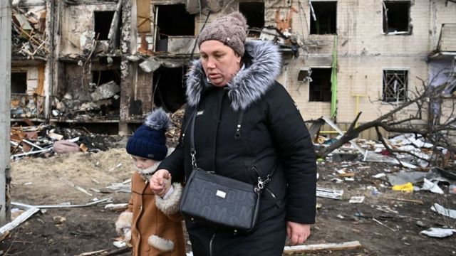 A woman and a girl escape from a building damaged by a missile in Kiev.
