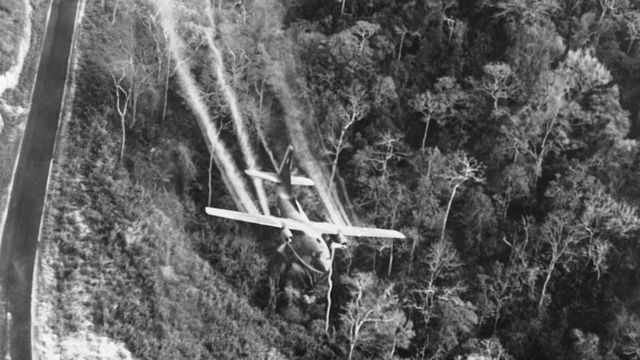 Um avião lança agente laranja sobre uma floresta no norte do Vietnã em 1966