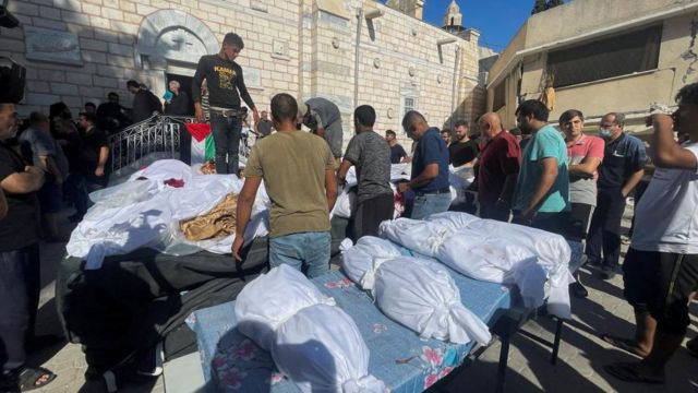 人们参加为在以色列袭击中丧生的巴勒斯坦人举行的葬礼。以色列空袭造成加沙城希腊东正教圣波菲里乌斯教堂遭破坏，并令多人死亡。