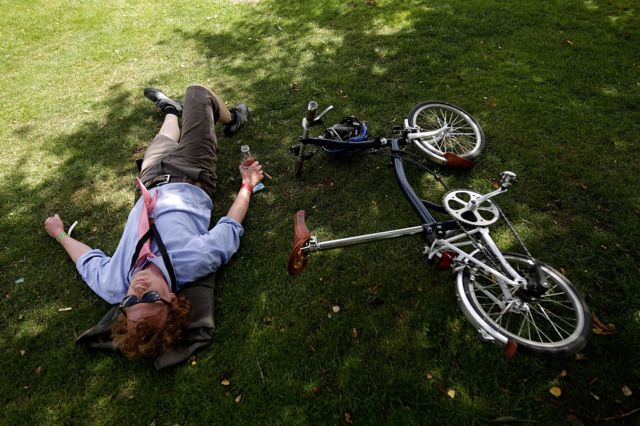 Un ciclista descansa junto a su bicicleta Brompton