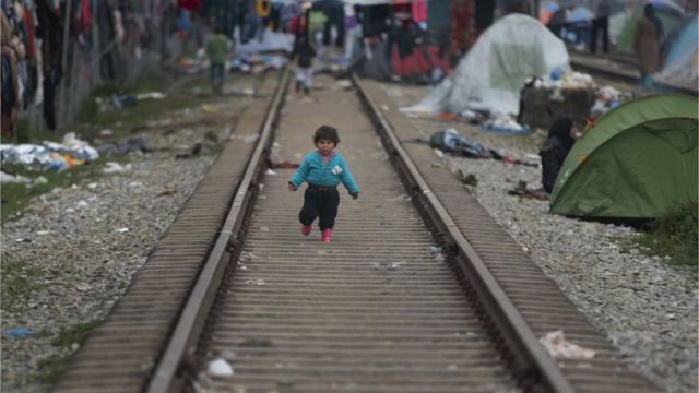 طفل مهاجر يمشي على قضبان القطار شمال اليونان