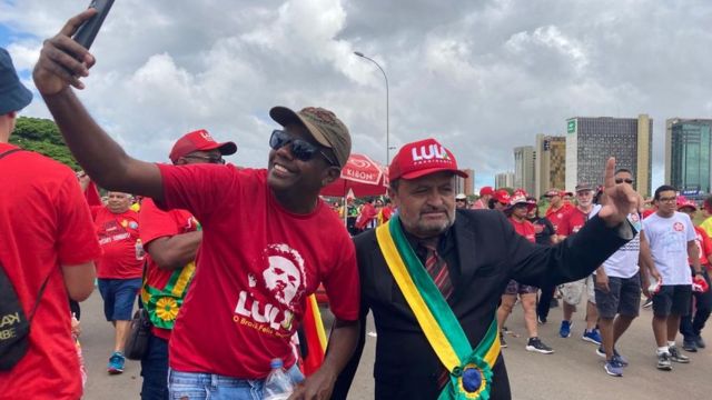 Two supporters of President Lula da Silva dressed in red