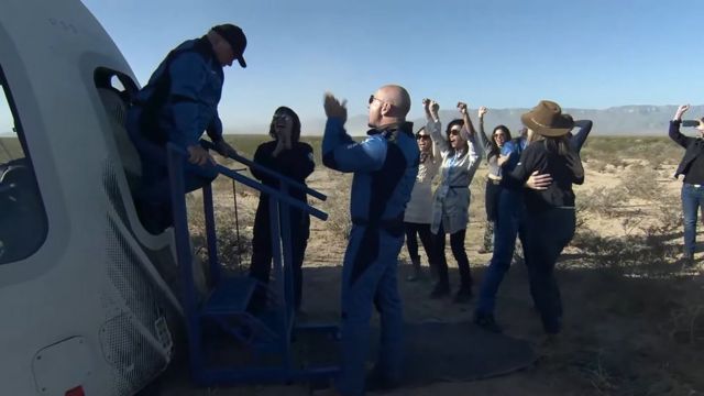 Jeff Bezos applaudit alors que William Shatner sort de la capsule New Shepard de Blue Origin après son atterrissage dans l'État américain du Texas.