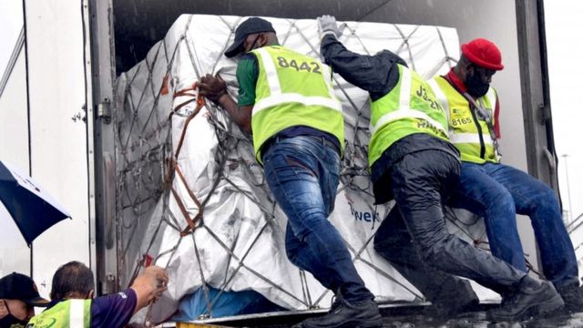 Workers unload the first vaccine shipment to arrive in South Africa