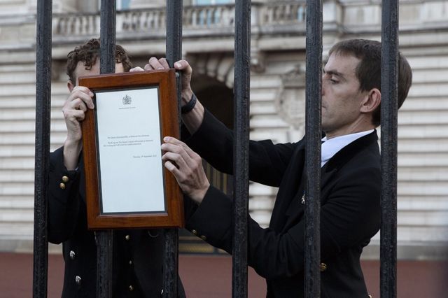 A member of royal household staff posts a notice on the gates of the Buckingham Palace in London announcing the death of Queen Elizabeth I