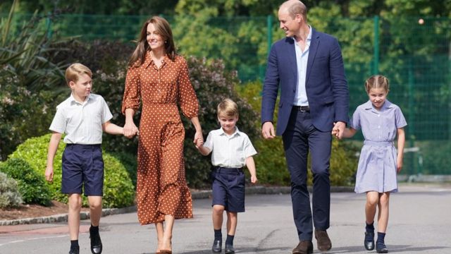 El príncipe George, la duquesa Kate de Cambridge, el príncipe Louis, el príncipe William y la princesa Charlotte caminando de la mano en el primer día de los niños en Lambrook School, cerca de Windsor.
