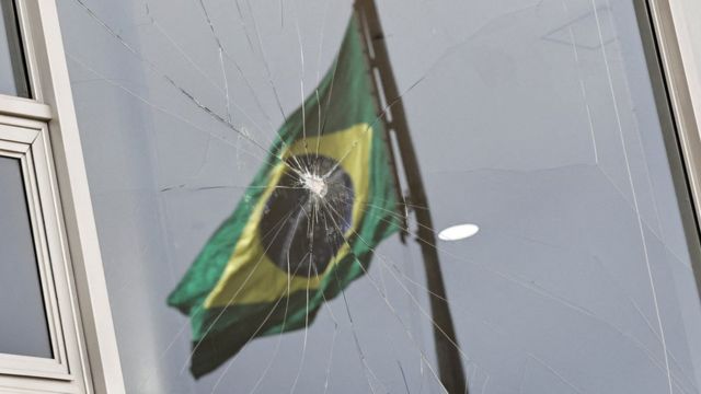 Imagen de la bandera de Brasil reflejada en vidrios rotos