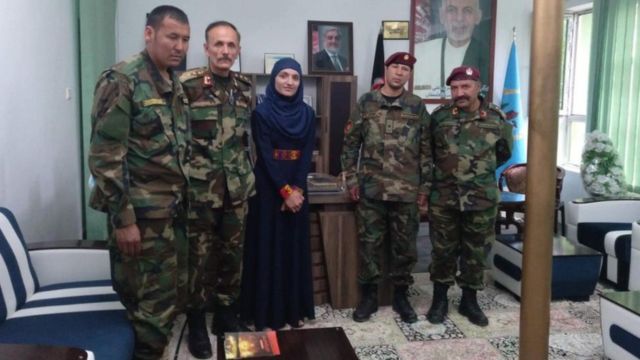 Zarifa Ghafari com homens vestidos com roupas militares