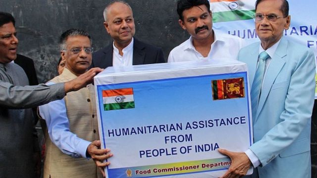 Indian High Commissioner to Sri Lanka Gopal Baglai sends a consignment of humanitarian aid to Sri Lanka's Foreign Minister Jamini Peiris (right) as a result of the country's economic crisis, at a port in Colombo on 22 May 2022