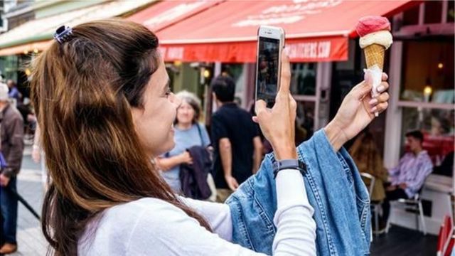 mulher tirando foto de sorvete com o celular