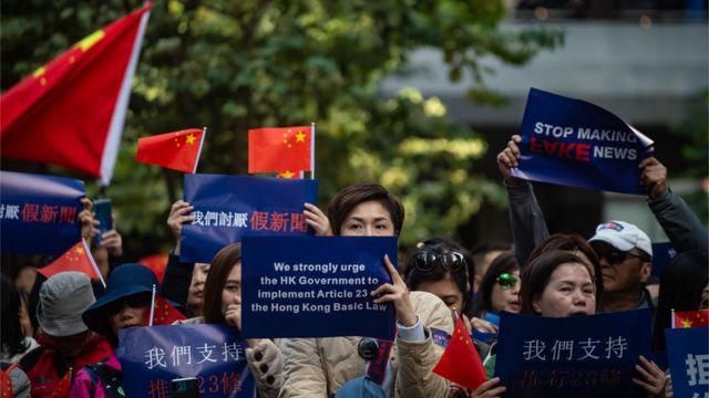 香港湾仔某亲政府示威上一群女示威者举起“讨厌假新闻”、“支持二十三条立法”等标语与中国国旗（7/12/2019）