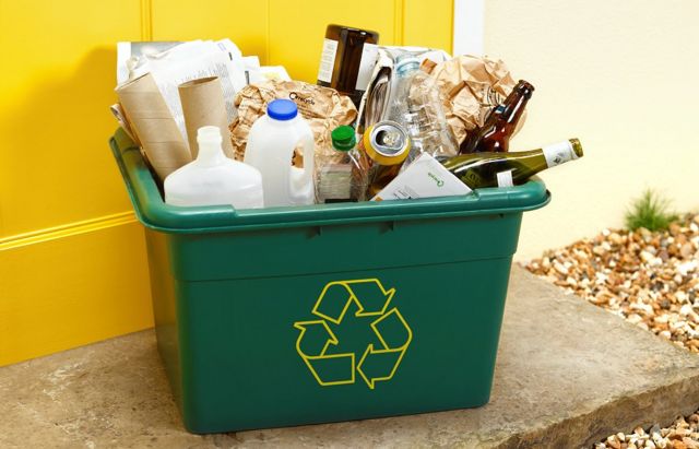Contenedor de reciclaje con el símbolo y desperdicios