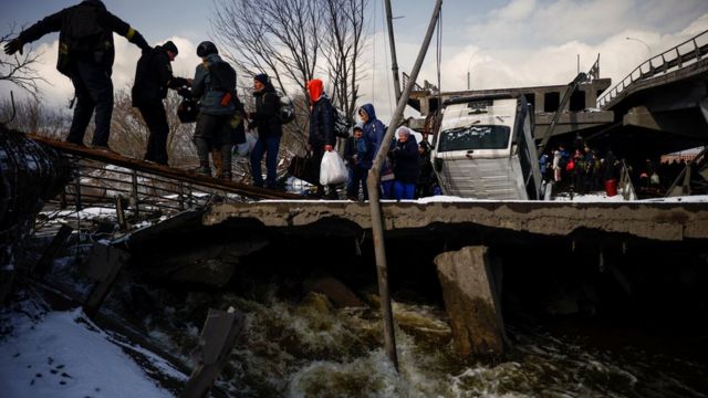 أشخاص يعبرون نهر اربين من خلال جسر مدمر أثناء فرارهم من تقدم القوات الروسية في بلدة إيربين خارج كييف، أوكرانيا