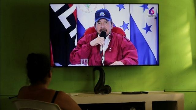 Una mujer mira en televisión un discurso de Daniel Ortega