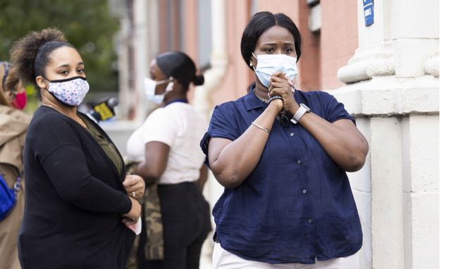 Anxious parents in face masks watching their children go back to elementary school in New York for the first time since March