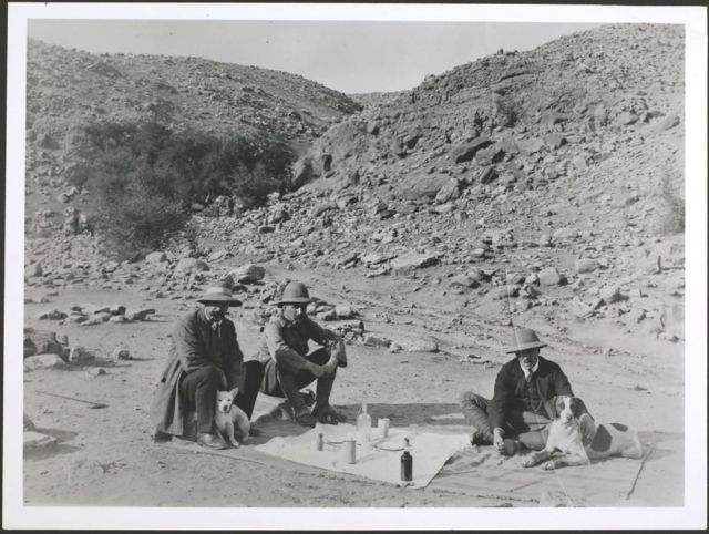 Oil mining pioneer George Bernard Reynolds (left), who drilled the first successful well, with Williams and another attendee at a picnic near Masjid i-Suleiman in Persia, Iran with their dogs in the early 20th century.